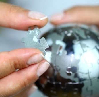 Hands holding puzzle globe