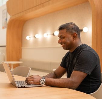 MBA student smiling in front of laptop