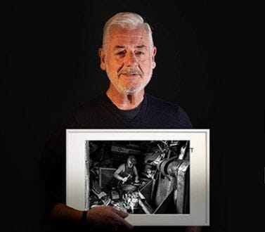 male photography contest winner holding his award winning work