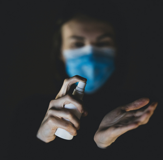 Health worker applying spray to hands | Carolyn Hudson wins 2021 Australasian Epidemiological Association (AEA) Top Student Prize | Torrens Uni