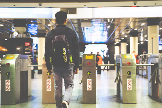 student walking towards train station gates