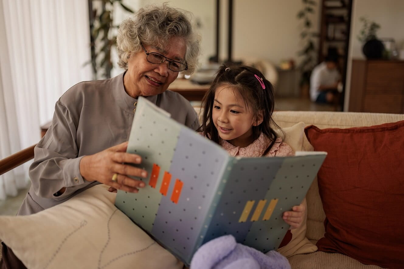 Older woman reading book to a child