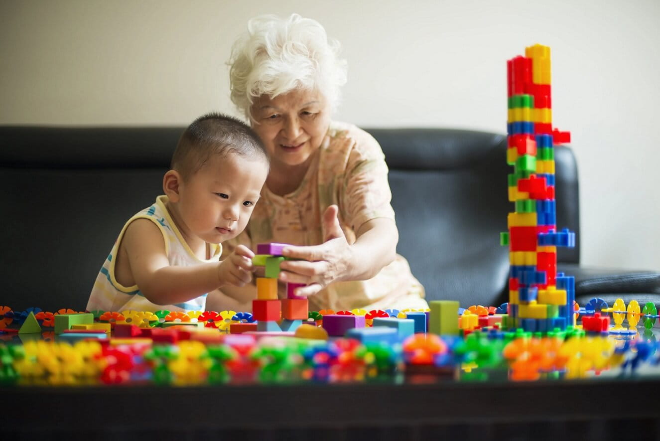 Older woman playing Lego with a child