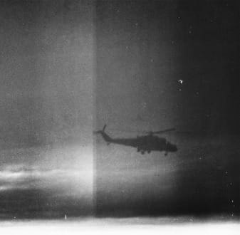 Black and white photo of a helicopter in flight