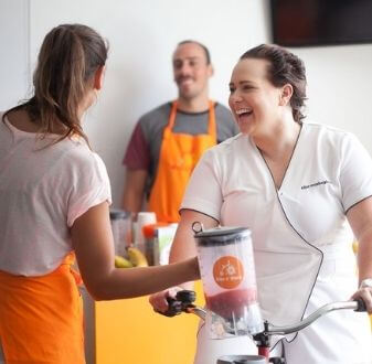 woman using blender bike and smiling to employee