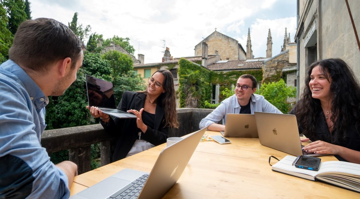 4 happy IT employees meet outdoors