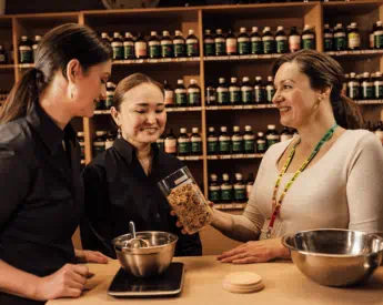 academic showing student how to pour liquid herbs in clinic | Torrens University