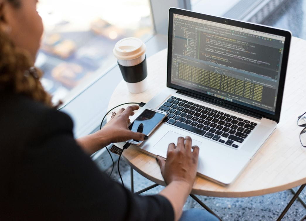 woman with coffee in front of analytics screen