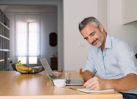 Man studying on laptop sitting at a desk