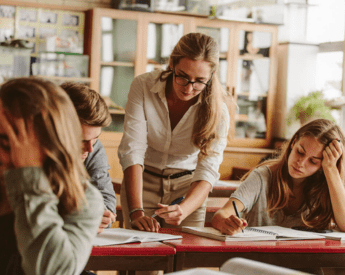 education-courses-women-leaning-on-desk-talking-to-students-new-hero-tua