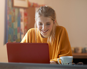 Torrens University Australia Events | Virtual Open Day | Student smiling on laptop